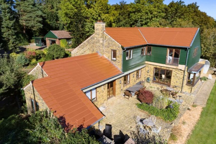 Maison à toiture photovoltaïque terracotta et bardage vert